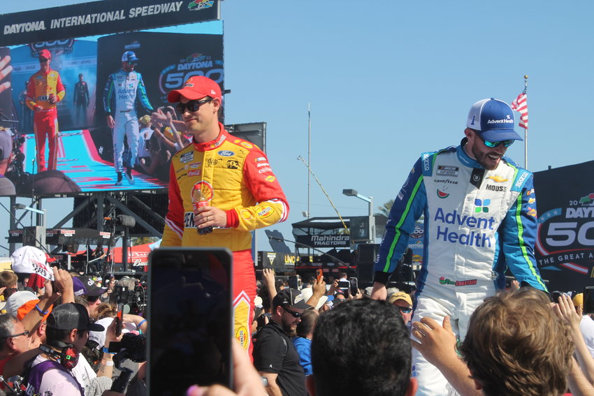 Drivers Joey Logano and Ross Chastain greet fans before racetime.